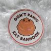 Beautiful "Don't Panic Eat Panic" Sticker made with waterproof holographic sticker paper—art created by Faith Trottier.